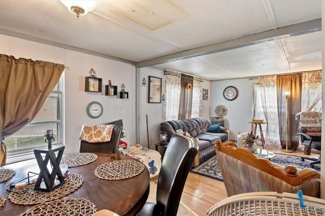dining room with light wood finished floors and beam ceiling