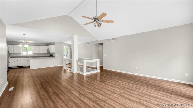 unfurnished living room with dark wood-style floors, a ceiling fan, beam ceiling, baseboards, and high vaulted ceiling
