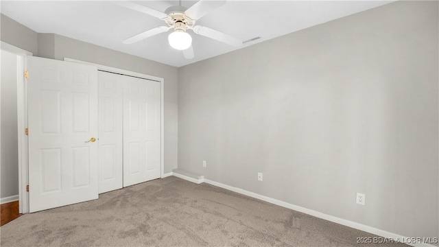 unfurnished bedroom with carpet, baseboards, a closet, and a ceiling fan