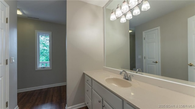 bathroom featuring wood finished floors, vanity, and baseboards