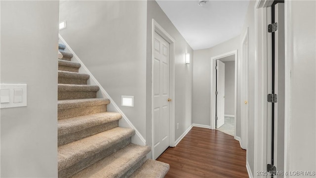 staircase with wood finished floors and baseboards