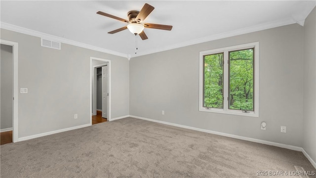 unfurnished room featuring carpet floors, ceiling fan, crown molding, and baseboards