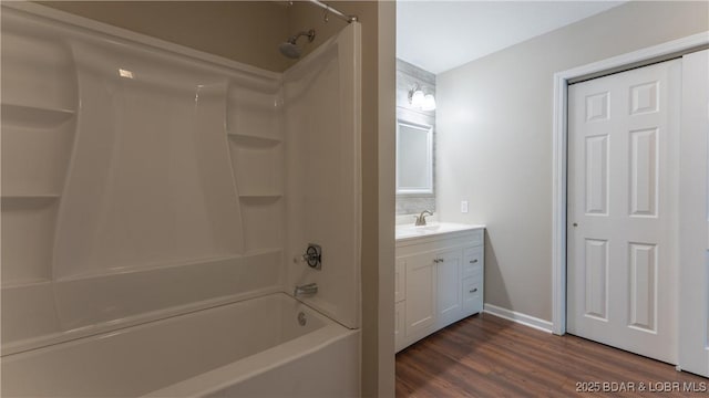 full bathroom with wood finished floors, vanity, bathtub / shower combination, and baseboards