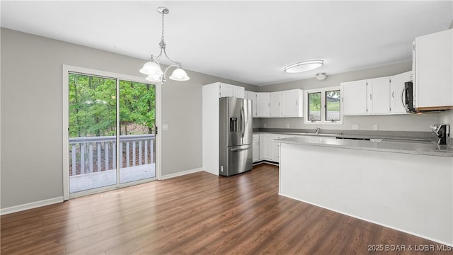 kitchen with stainless steel appliances, a peninsula, a chandelier, and dark wood-style flooring