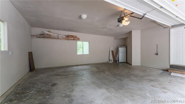garage featuring refrigerator and a garage door opener