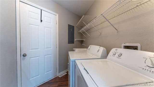 laundry room featuring washer and dryer, electric panel, and dark wood-style flooring