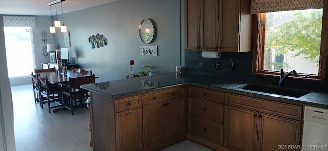 50 Shannon Cir, Sunrise Beach, MO 65079 - kitchen with a sink, dishwasher, a peninsula, backsplash, and brown cabinets
