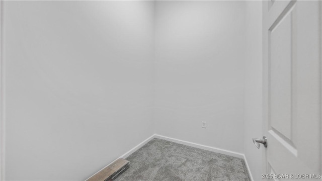 carpeted spare room featuring baseboards