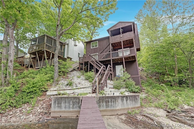 26553 Mesa Dr, Rocky Mount, MO 65072 - back of property with stairs, a deck, and a sunroom
