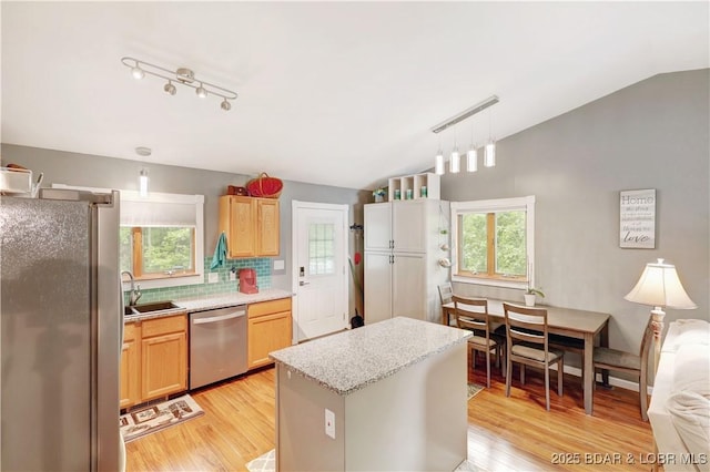 26553 Mesa Dr, Rocky Mount, MO 65072 - kitchen with appliances with stainless steel finishes, lofted ceiling, light wood-type flooring, a center island, and tasteful backsplash