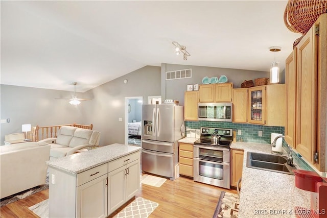 26553 Mesa Dr, Rocky Mount, MO 65072 - kitchen with appliances with stainless steel finishes, vaulted ceiling, light wood-style floors, tasteful backsplash, and open floor plan