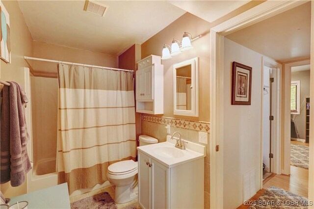 26553 Mesa Dr, Rocky Mount, MO 65072 - full bath with vanity, shower / tub combo with curtain, wood finished floors, and tile walls
