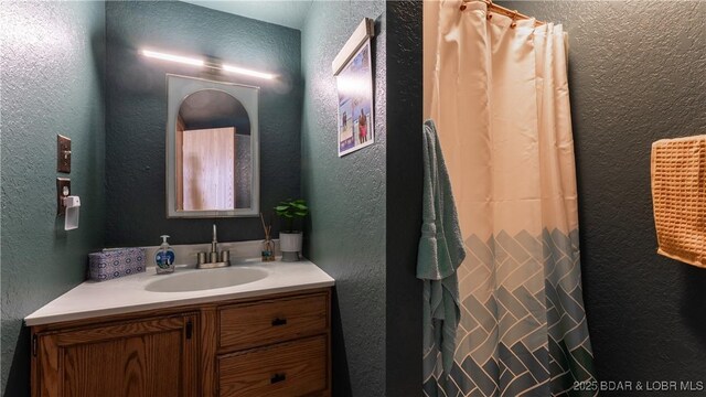 26505 Mesa Dr, Rocky Mount, MO 65072 - full bathroom featuring a textured wall, vanity, and curtained shower