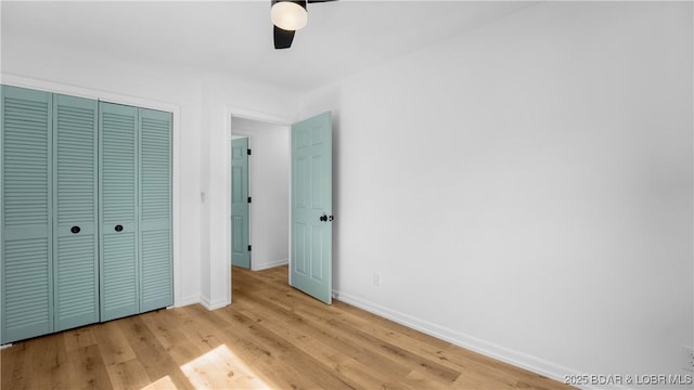 unfurnished bedroom with baseboards, light wood-style flooring, a closet, and ceiling fan