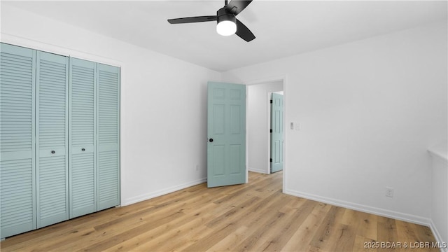 unfurnished bedroom featuring baseboards, light wood-style floors, a closet, and ceiling fan
