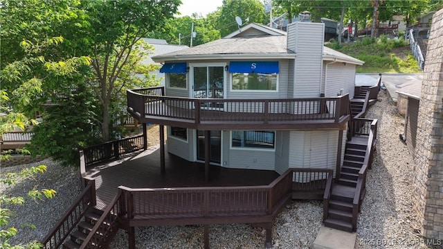 rear view of property featuring a wooden deck, stairs, and a chimney