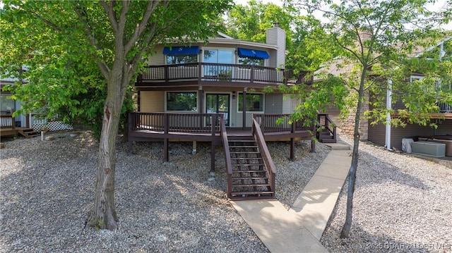 rear view of property with stairs and a deck