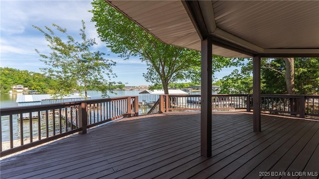 wooden deck featuring a water view and fence