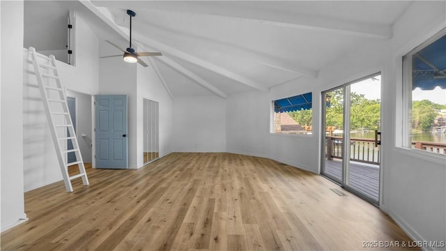 additional living space with wood finished floors, beam ceiling, a ceiling fan, baseboards, and high vaulted ceiling