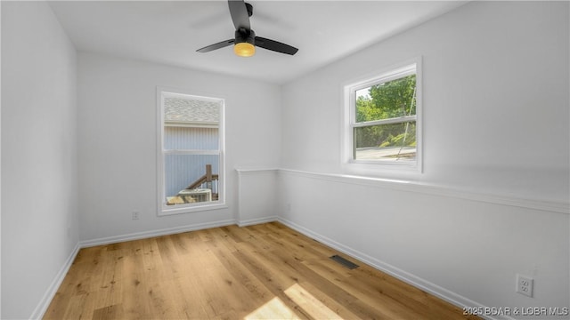 empty room with light wood finished floors, baseboards, and a ceiling fan