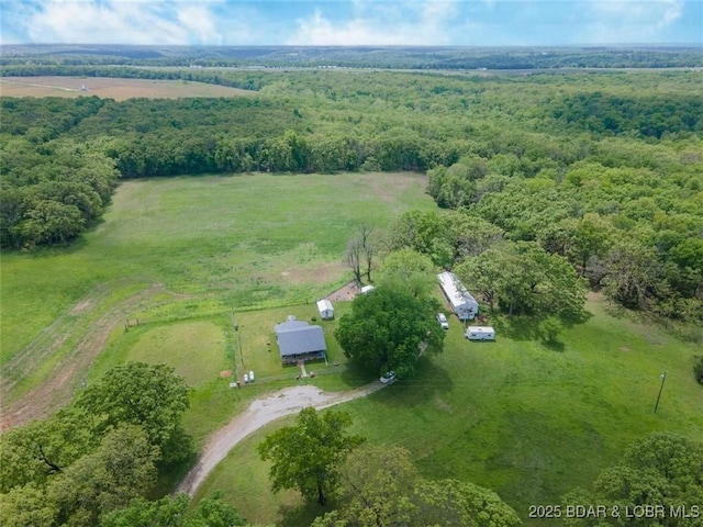 aerial view of property and surrounding area with rural landscape and a heavily wooded area