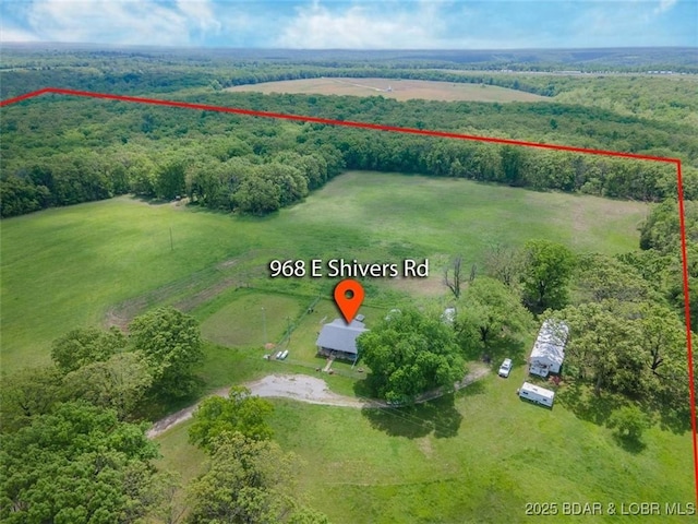 aerial view of sparsely populated area featuring property boundaries highlighted and a heavily wooded area