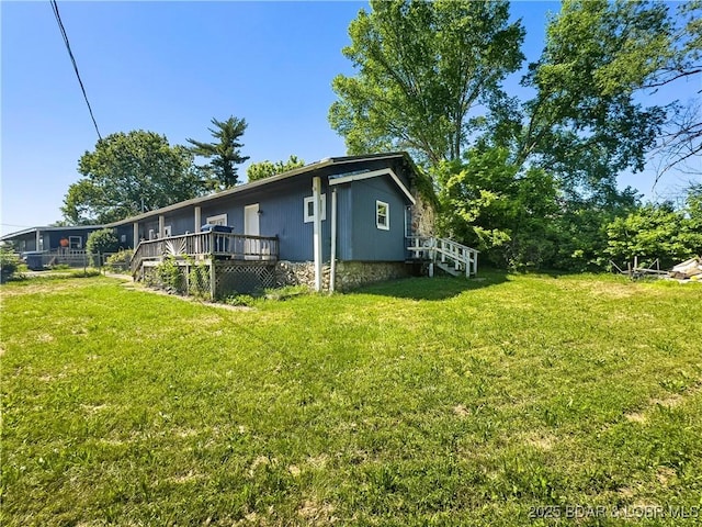 view of side of home featuring a lawn and a wooden deck