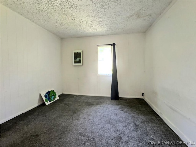 carpeted empty room featuring a textured ceiling