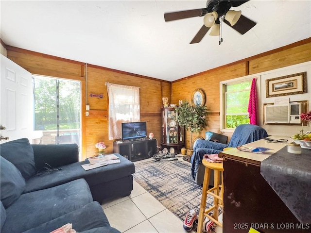 living room with plenty of natural light, light tile patterned floors, wooden walls, a ceiling fan, and vaulted ceiling