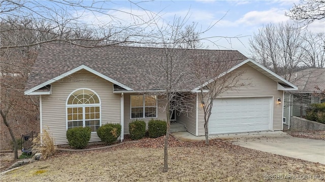 view of front facade featuring a garage, a shingled roof, and driveway