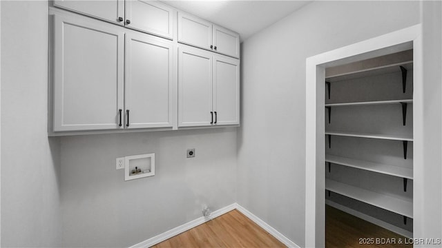 laundry room featuring electric dryer hookup, cabinet space, washer hookup, light wood-style floors, and baseboards