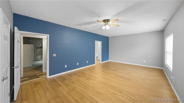 unfurnished bedroom featuring light wood-style floors, baseboards, connected bathroom, and ceiling fan