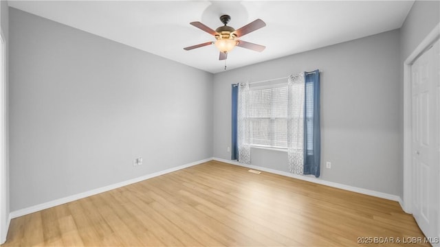 unfurnished room featuring light wood finished floors, baseboards, and ceiling fan