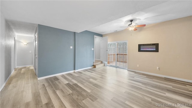 unfurnished living room featuring a ceiling fan, wood finished floors, and baseboards