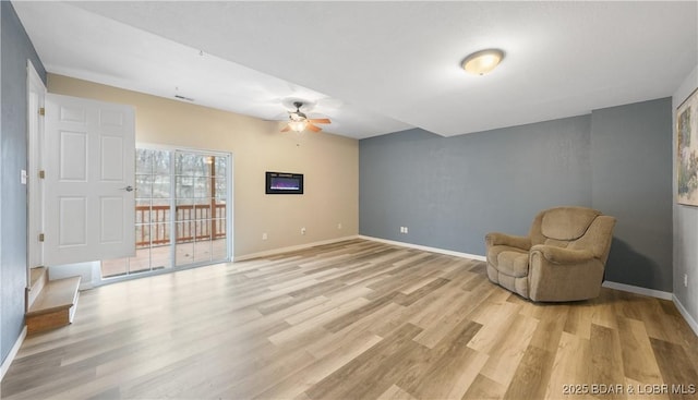 unfurnished room with ceiling fan, light wood finished floors, and baseboards
