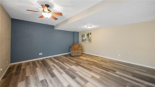 unfurnished room with ceiling fan, wood finished floors, and baseboards