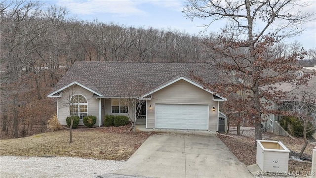 ranch-style home featuring an attached garage, concrete driveway, and roof with shingles