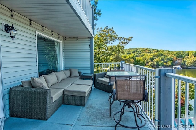 balcony with an outdoor living space and a forest view