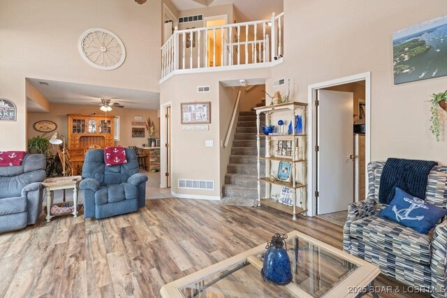 33367 Emerald Rd, Sunrise Beach, MO 65079 - living room with stairs, wood finished floors, a towering ceiling, and ceiling fan