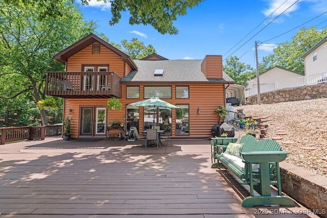 33367 Emerald Rd, Sunrise Beach, MO 65079 - rear view of property featuring a balcony, a shingled roof, a deck, and outdoor dining area