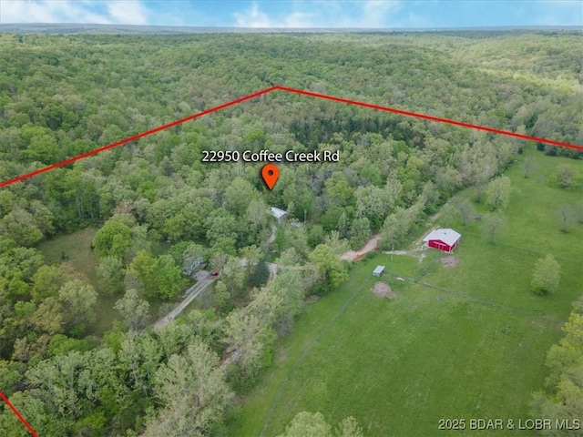 aerial view of sparsely populated area with a forest and property parcel outlined