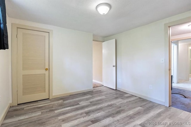unfurnished bedroom featuring wood finished floors and baseboards