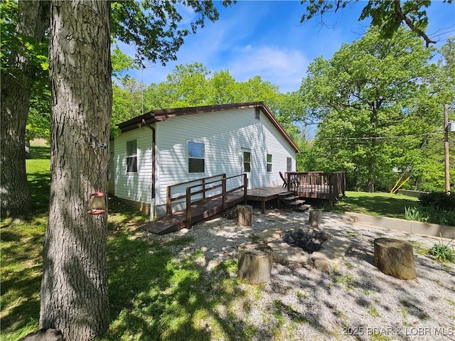 back of house with a wooden deck and a yard