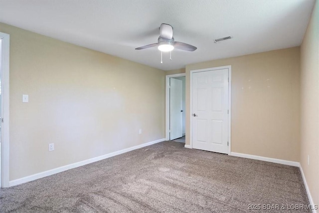 empty room featuring carpet floors, a ceiling fan, and baseboards