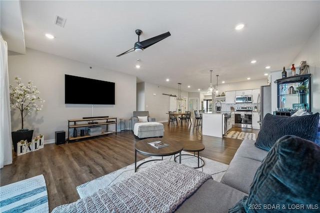 living room with a ceiling fan, recessed lighting, wood finished floors, and baseboards