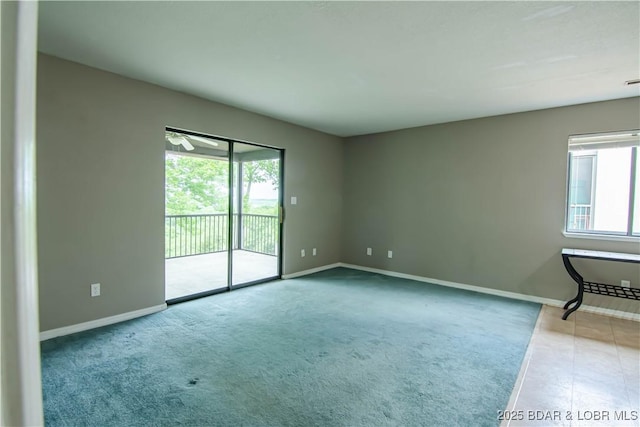 carpeted spare room featuring plenty of natural light and baseboards
