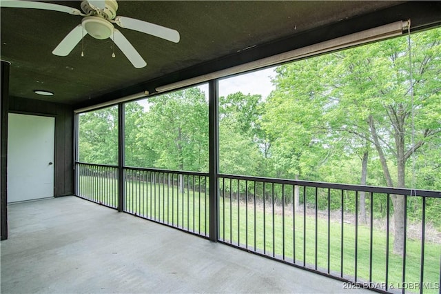 unfurnished sunroom featuring ceiling fan