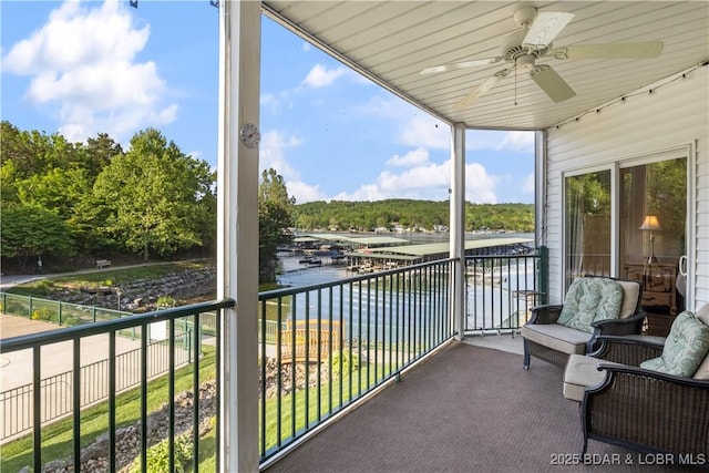 balcony with a water view and a ceiling fan
