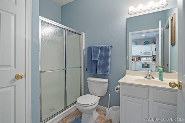 bathroom featuring a stall shower, toilet, vanity, tile patterned floors, and baseboards