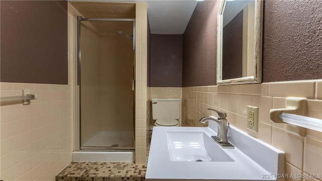 907 Sunnyview Cir, Eldon, MO 65026 - bathroom featuring tile walls, a shower stall, toilet, a wainscoted wall, and vanity